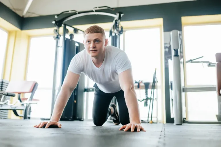 Najlepsze ćwiczenia dla początkujących. Mężczyzna wykonuje pompkę z kolan na treningu.