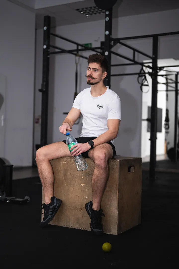Patryk Michałek trener personalny Bydgoszcz podczas przerwy w treningu personalnym na siłowni.