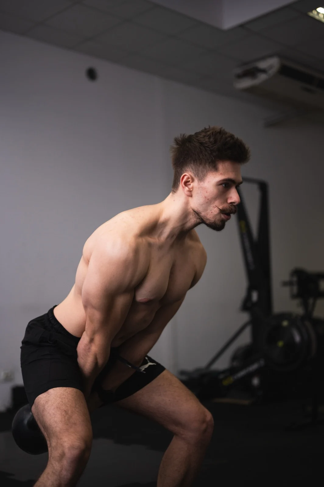 Trener personalny podczas treningu z kettlebellami na sali w Bydgoszczy